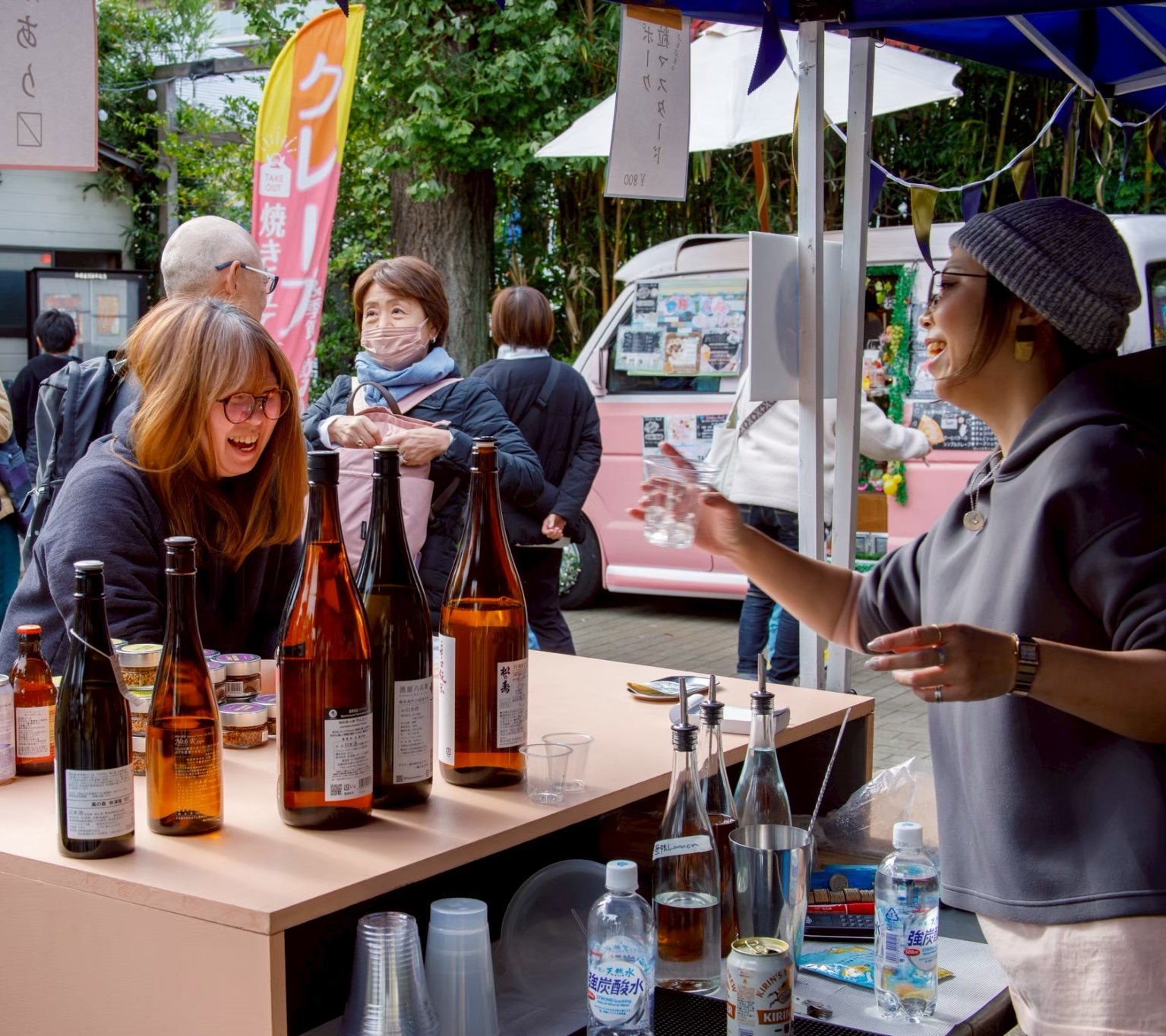 お酒のブースで談笑して笑顔を見せる来場者